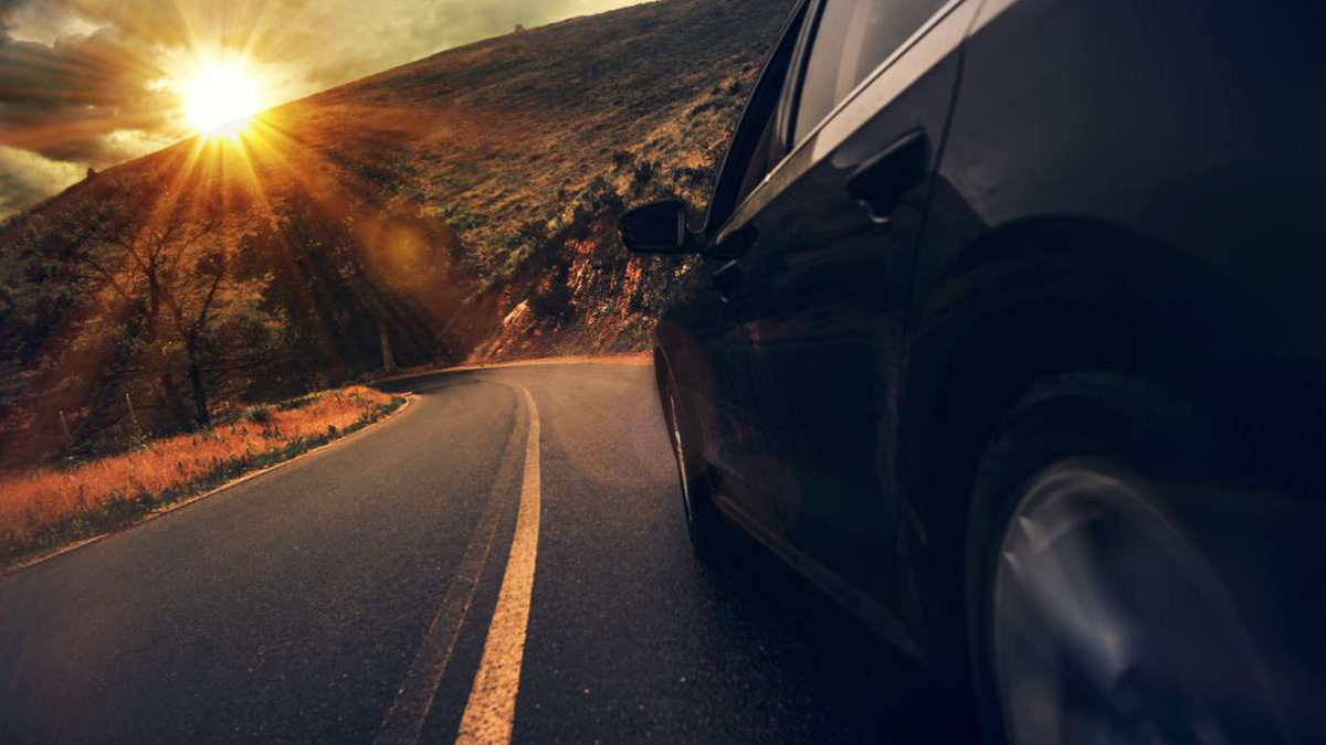 a dacia car turns a corner while sun is shining