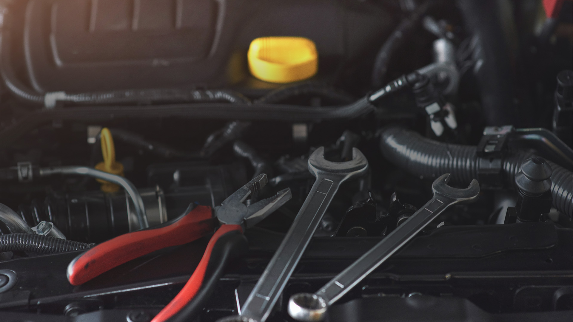 some tools on top of a opened car hood