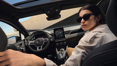 a woman in the front passenger seat and the glass ceiling of a of a renault captur