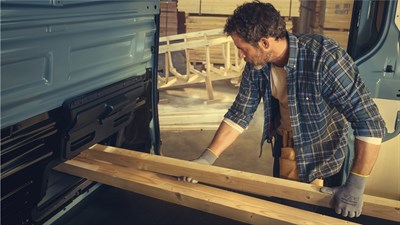 a man putting some wooden sticks inside the renault new trafic